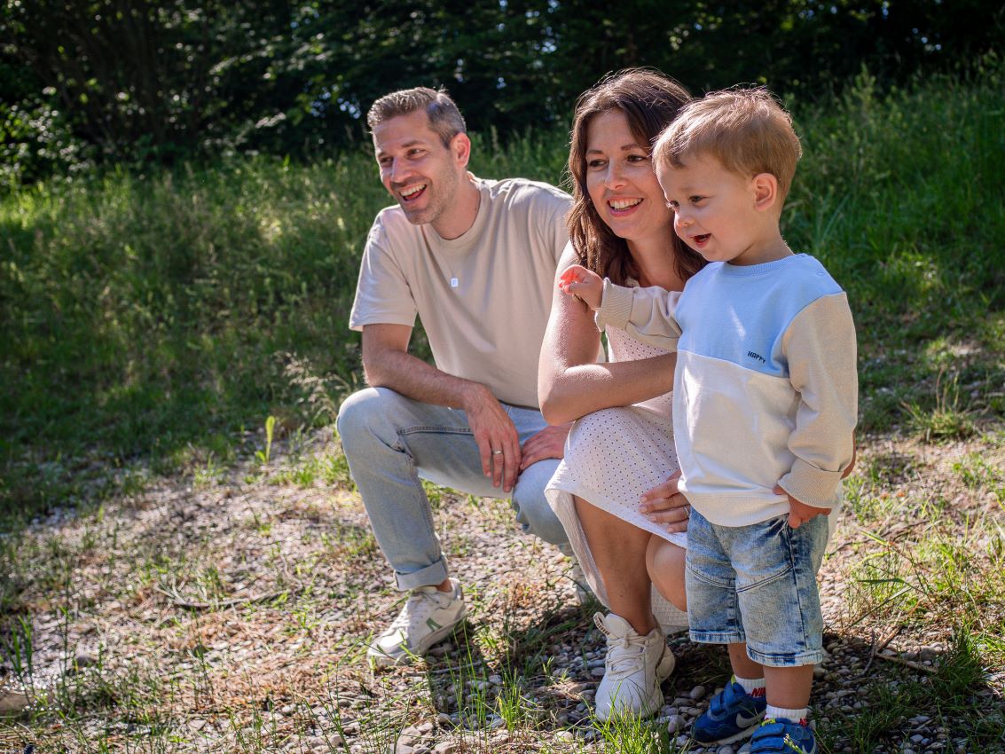 Familie mit einem kleinen Jungen, der im Freien lächelt und Spaß hat. Familienshooting in und um Geretsried Bad-Tölz Wolfratshausen