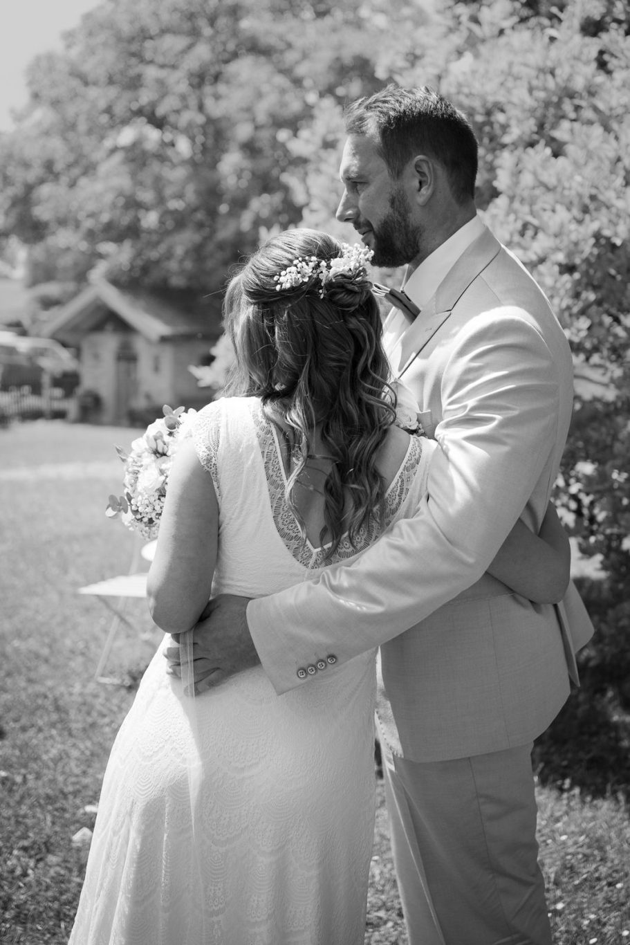 Hochzeit schwarz-weiß-Foto des Brautpaares welches man von hinten sieht, wie sie gegenseitig den Arm umeinander legen